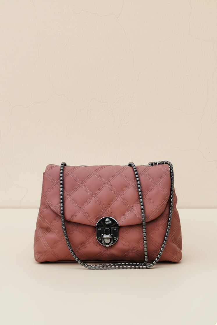 Blush quilted shoulder bag with metal lock and chain strap.